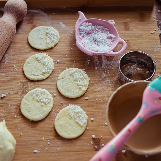 Den Teig rolle ich dünn aus und steche 5cm Kreise aus. Mit etwas Eiweiß wird der Hagelzucker angeklebt.